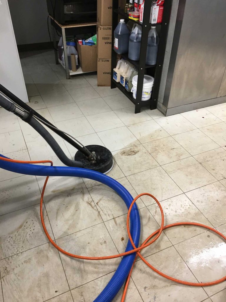 a file floor cleaning machine cleaning a tile floor leaving the grout and tile clean and shiny